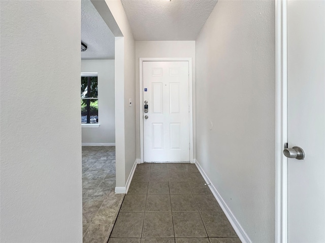 interior space with dark tile patterned flooring and a textured ceiling