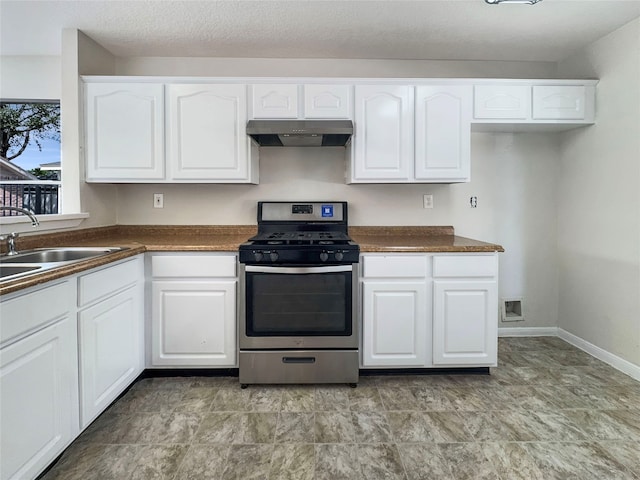 kitchen featuring white cabinetry, a textured ceiling, gas range, and sink