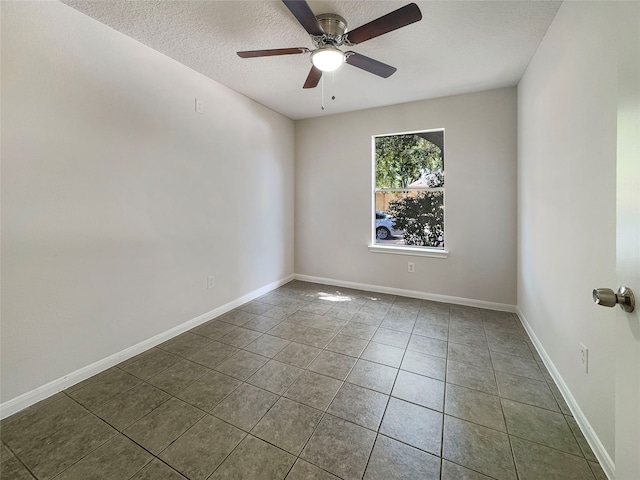 tiled spare room with a textured ceiling and ceiling fan