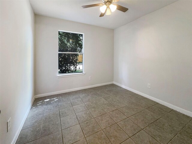 tiled spare room with ceiling fan