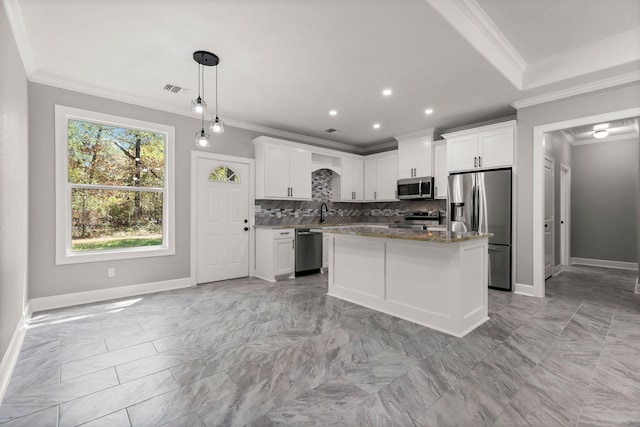 kitchen featuring a kitchen island, white cabinetry, appliances with stainless steel finishes, and decorative light fixtures