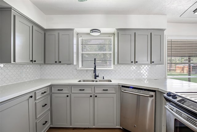 kitchen with stainless steel appliances, sink, and gray cabinets