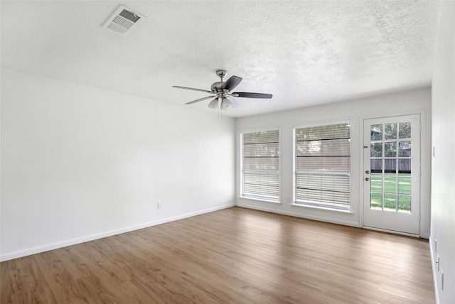 empty room featuring hardwood / wood-style flooring, a textured ceiling, and ceiling fan