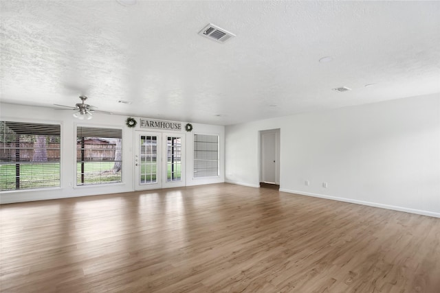 unfurnished living room featuring a textured ceiling, ceiling fan, and dark wood-type flooring