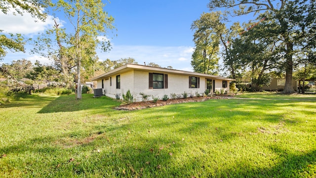 view of home's exterior with a lawn and central AC