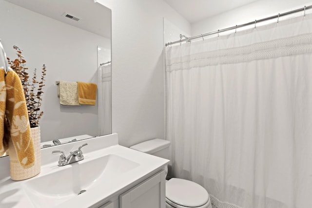 bathroom with walk in shower, vanity, and toilet