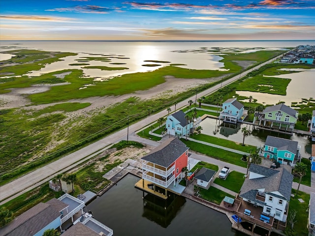 aerial view at dusk featuring a water view