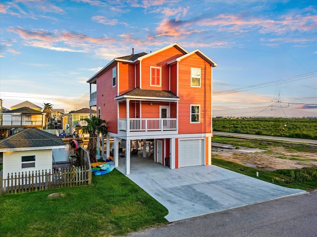 view of front of house featuring a balcony, a garage, and a yard