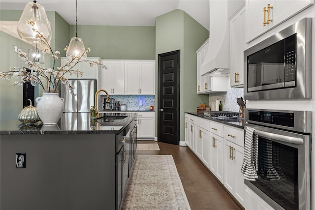 kitchen with sink, backsplash, white cabinets, and appliances with stainless steel finishes