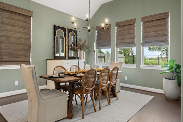 dining area featuring wood-type flooring, vaulted ceiling, and a chandelier