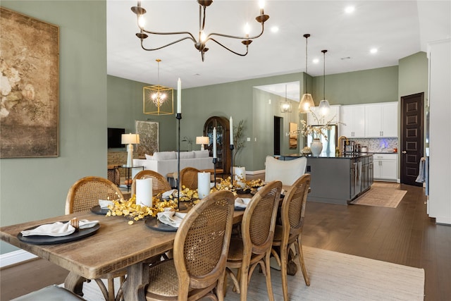 dining room with dark hardwood / wood-style flooring, sink, and a notable chandelier