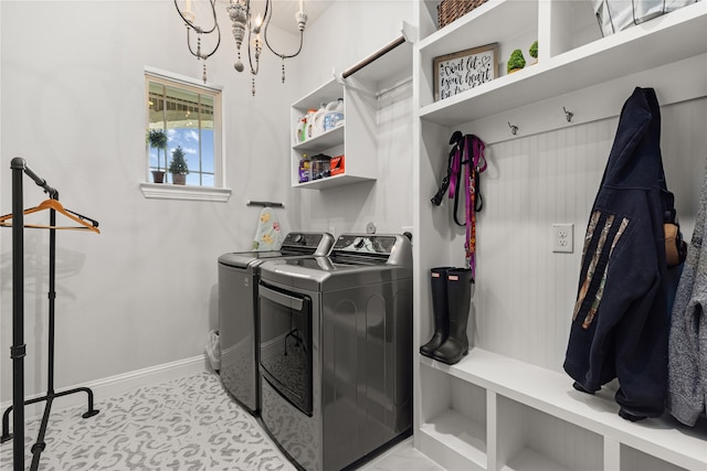 laundry room with washer and clothes dryer and a notable chandelier