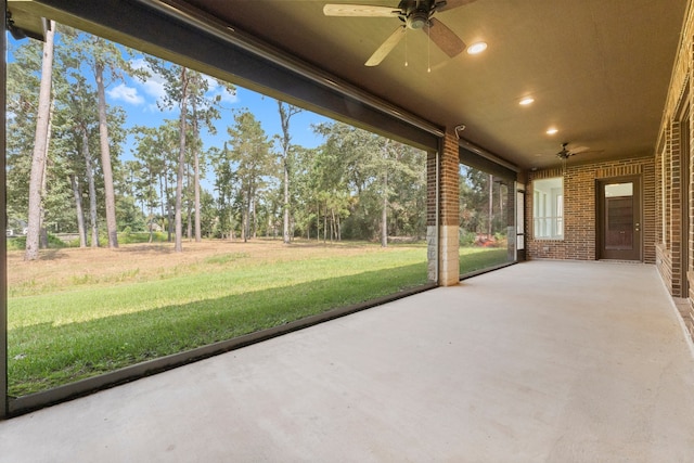 unfurnished sunroom featuring ceiling fan