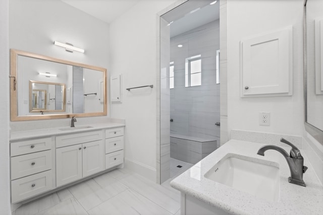 bathroom featuring a tile shower and vanity