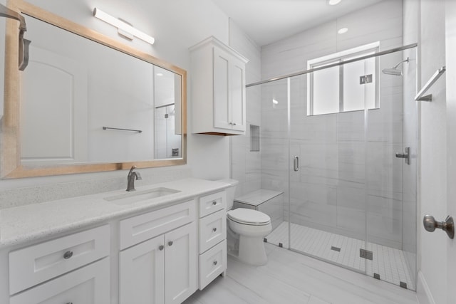 bathroom with vanity, toilet, and a shower with shower door