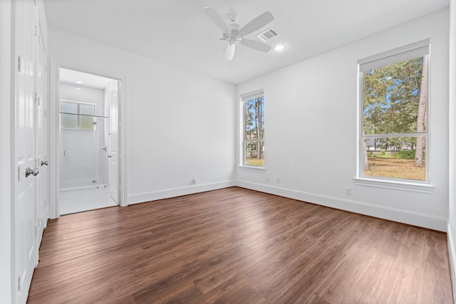 spare room featuring ceiling fan, plenty of natural light, and dark hardwood / wood-style floors