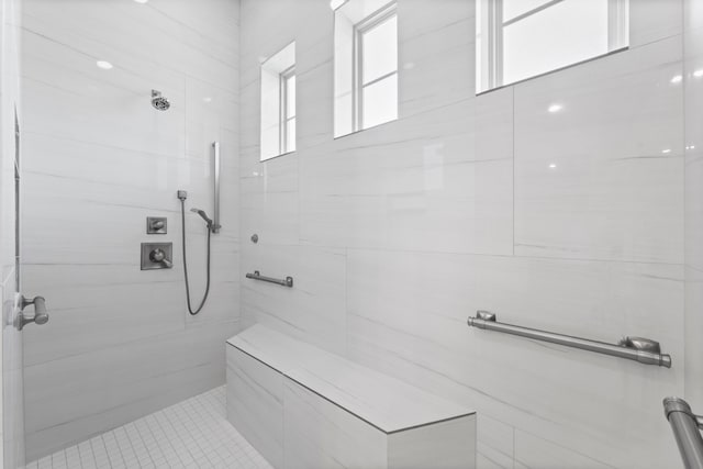 bathroom with a tile shower and tile patterned floors