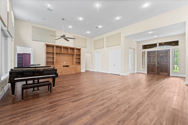 miscellaneous room with a high ceiling, ceiling fan, and hardwood / wood-style flooring