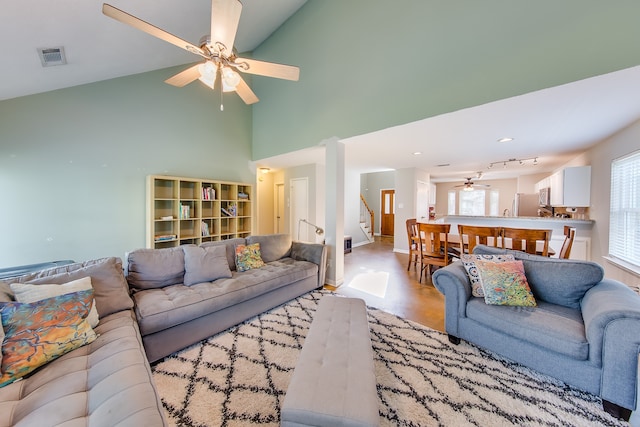 living room featuring ceiling fan and high vaulted ceiling