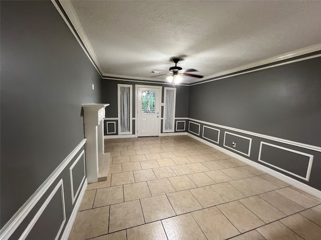 spare room featuring a textured ceiling, crown molding, and ceiling fan