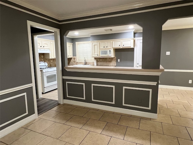 kitchen with white cabinets, tasteful backsplash, white appliances, custom exhaust hood, and ornamental molding