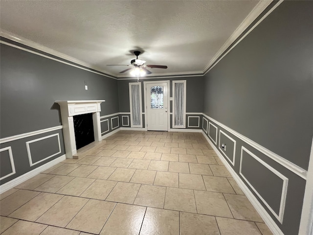 unfurnished living room featuring a textured ceiling, ceiling fan, and crown molding