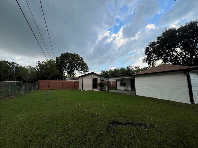 view of yard featuring a storage shed and a patio