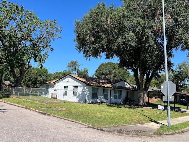 ranch-style house with a front yard and central AC unit