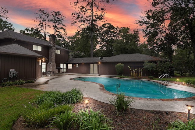 pool at dusk with a patio area