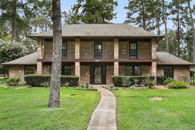 view of front facade featuring a balcony and a front lawn