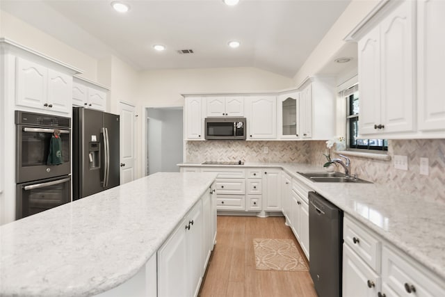 kitchen featuring appliances with stainless steel finishes, white cabinetry, sink, and light hardwood / wood-style flooring