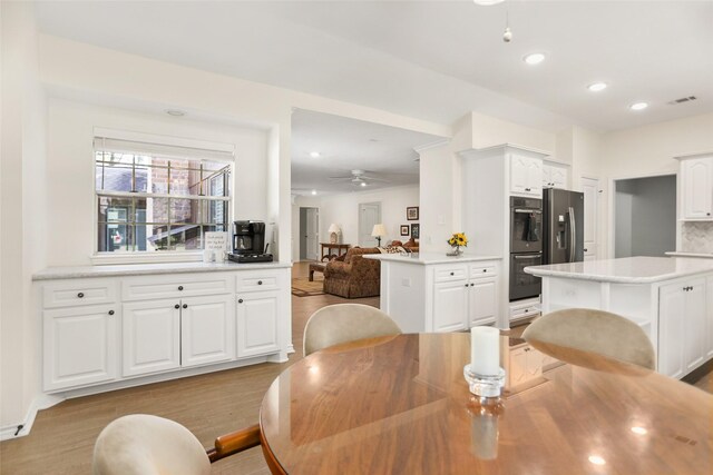 dining space with light hardwood / wood-style floors and ceiling fan