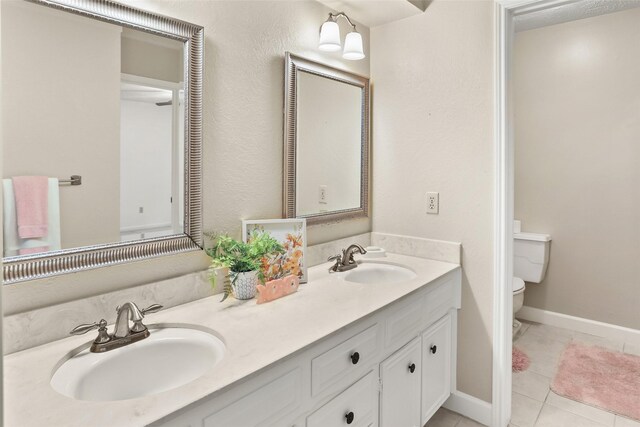 bathroom with tile patterned floors, vanity, and toilet