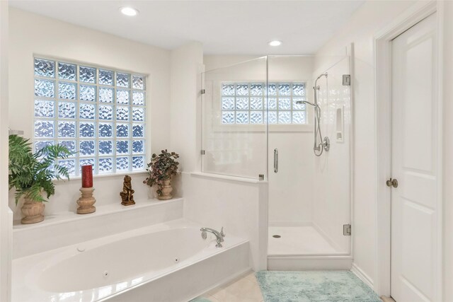 bathroom featuring shower with separate bathtub, a wealth of natural light, and tile patterned floors