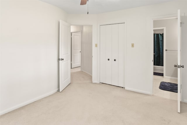 unfurnished bedroom featuring ceiling fan, a closet, and light carpet