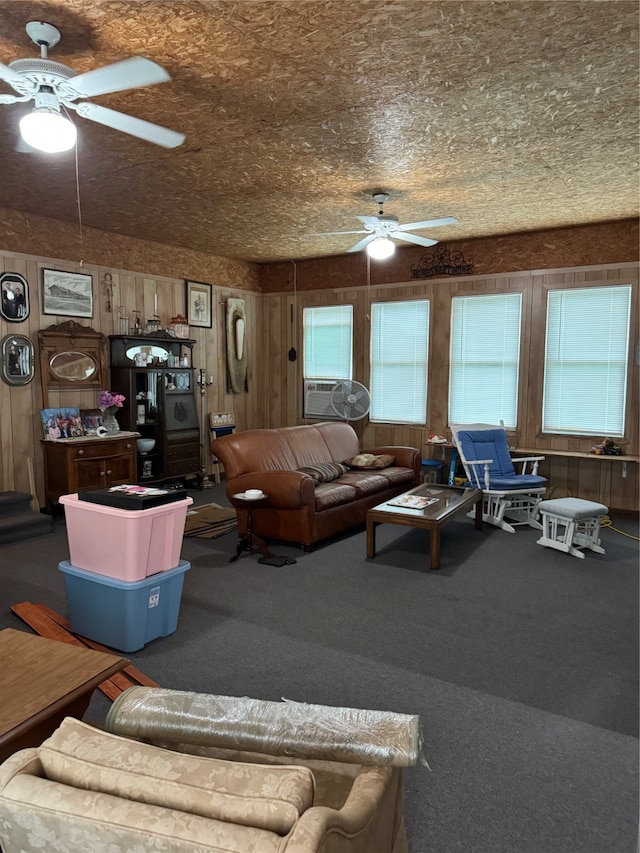 living room with wood walls, dark carpet, ceiling fan, and cooling unit