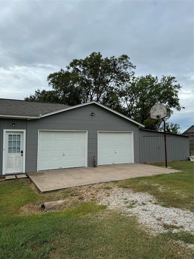 garage featuring a yard and wooden walls