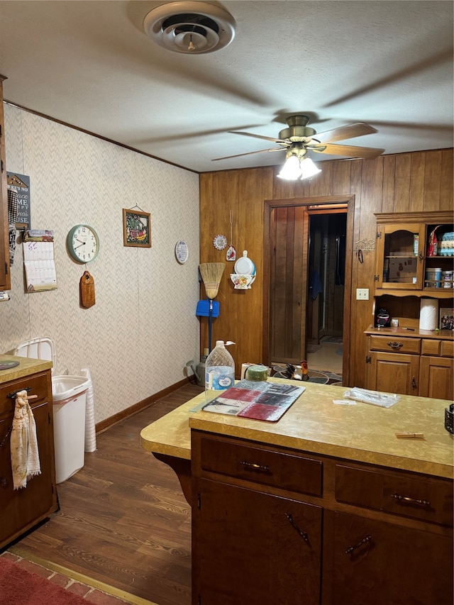 kitchen with wood walls, dark wood-type flooring, and ceiling fan