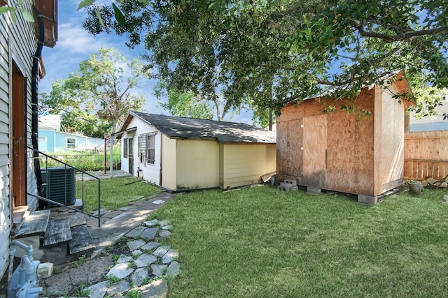 view of yard featuring central AC unit and a shed