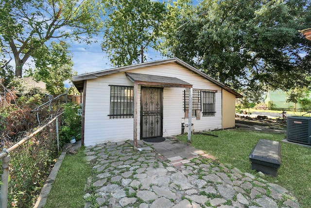 view of front of property featuring a front lawn and central AC