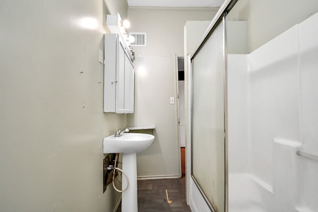 bathroom with wood-type flooring and a shower with door