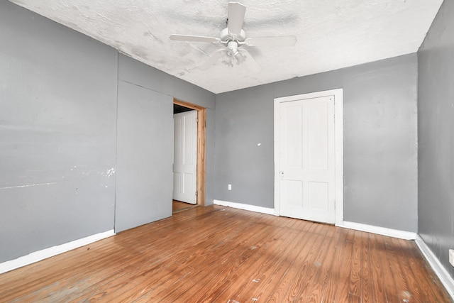 unfurnished bedroom featuring a textured ceiling, wood-type flooring, and ceiling fan