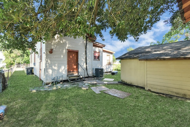 back of property with cooling unit and a lawn