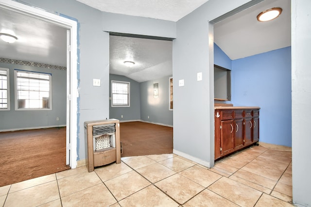 interior space with a textured ceiling, lofted ceiling, heating unit, and light colored carpet