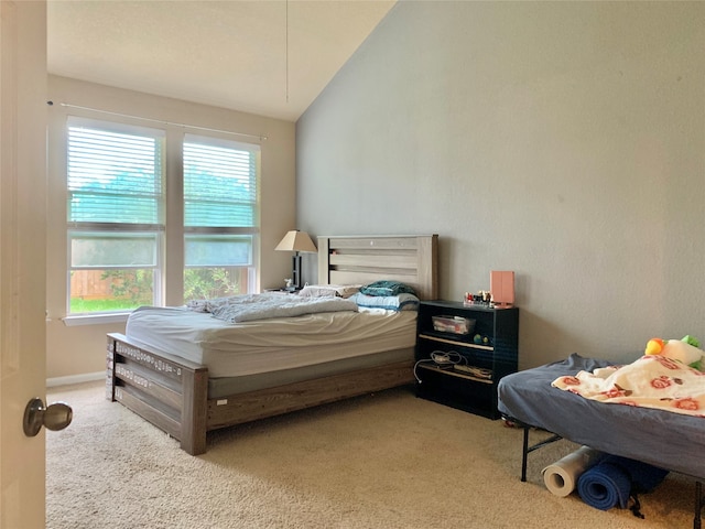 carpeted bedroom featuring lofted ceiling and multiple windows