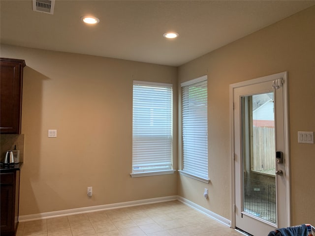 unfurnished dining area with light tile patterned flooring and plenty of natural light