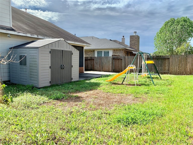 view of yard with a playground and a shed