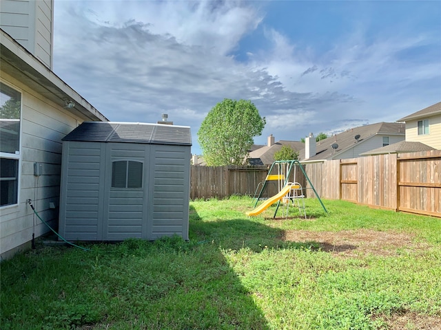 view of yard with a storage unit and a playground