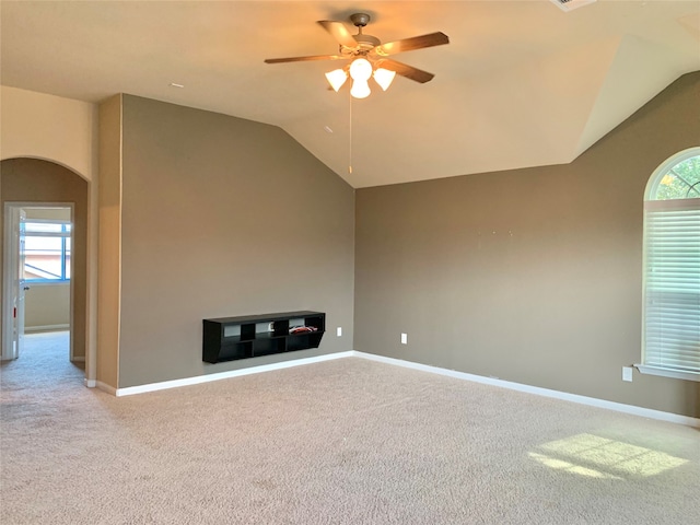 unfurnished living room featuring ceiling fan, light colored carpet, and vaulted ceiling