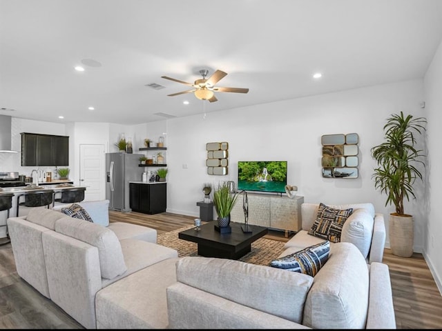 living room with ceiling fan, sink, and dark hardwood / wood-style flooring